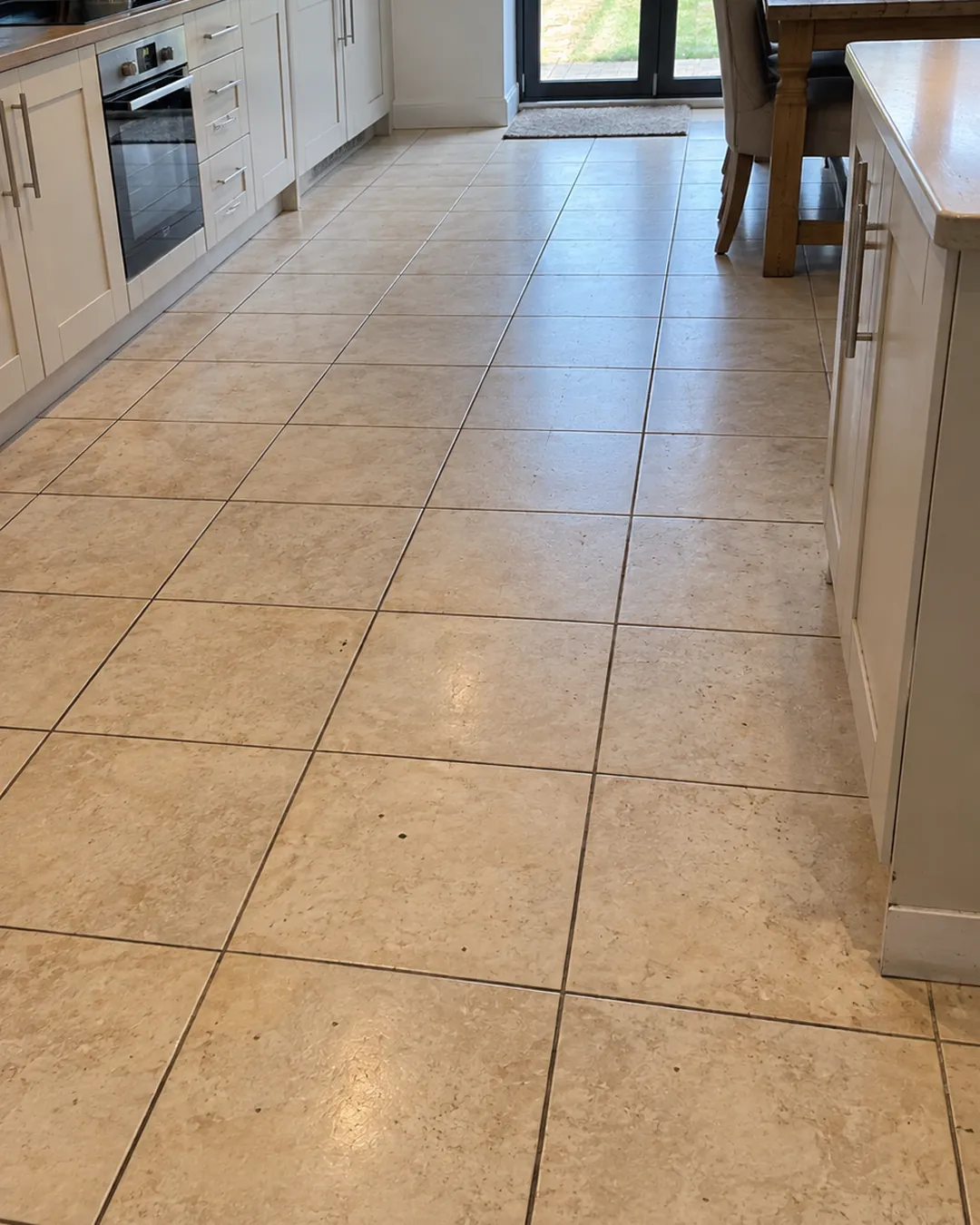 Customer photo of an old tiled kitchen floor sent on WhatsApp